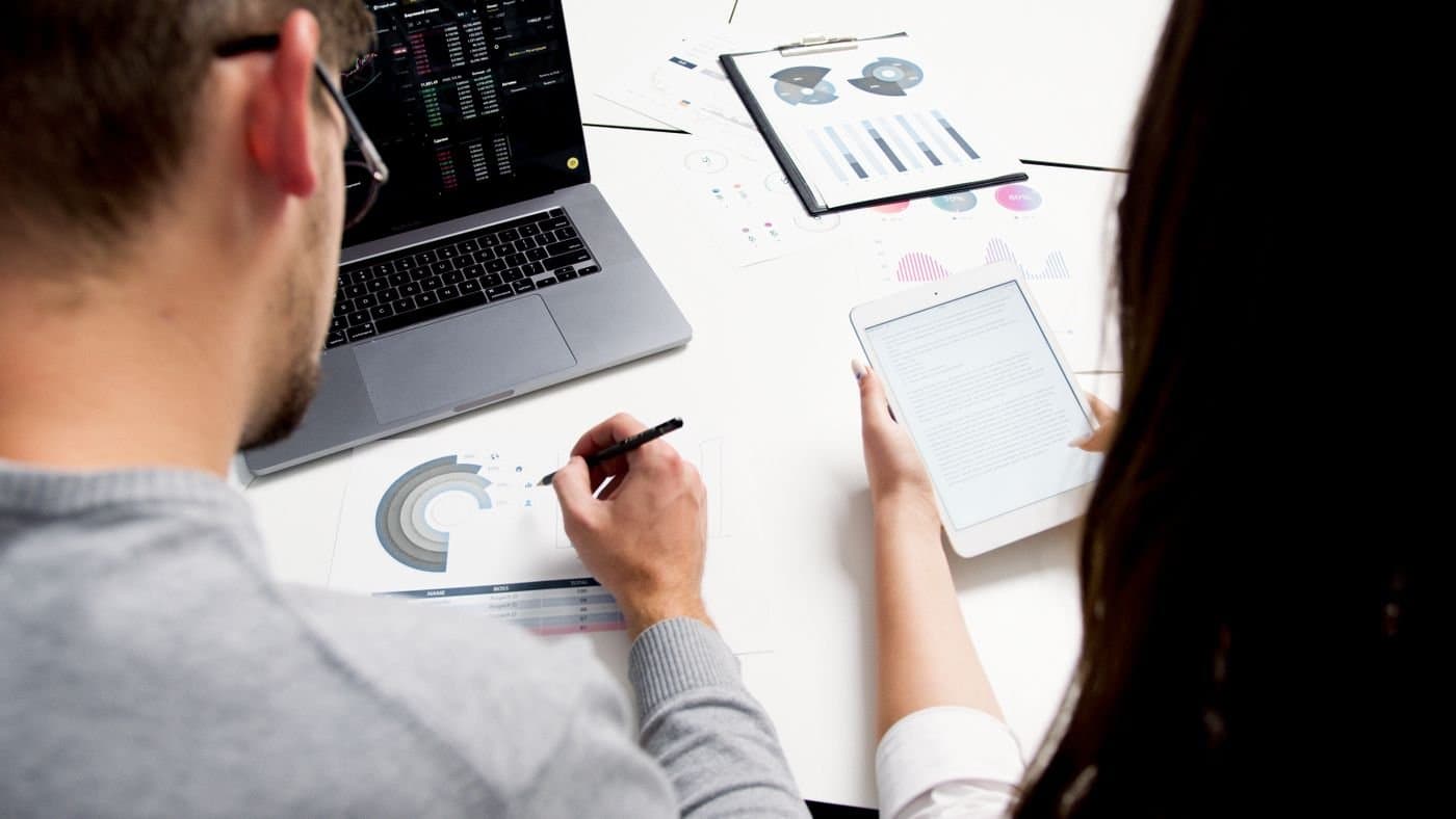 Couple reviewing charts and notes while planning household finances